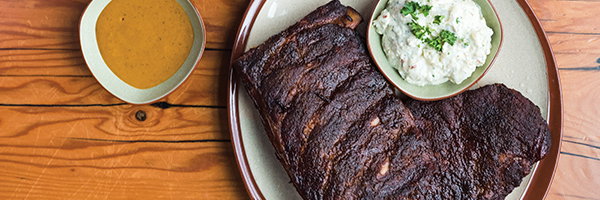 OMC's pork and grits on a table, part of the best barbecue in Minnesota.