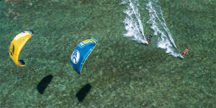 An aerial view of people kiteboarding.