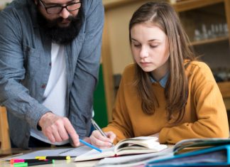 Photo of a teacher and student looking at a book