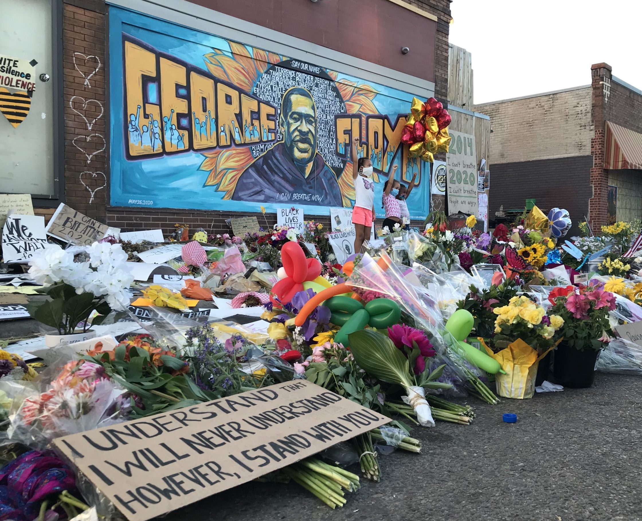 Tributes arranged before a mural of George Floyd on the side of Cup Foods in south Minneapolis, where Floyd was killed