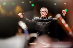 Minnesota Orchestra music director Osmo Vänskä standing and conducting performers