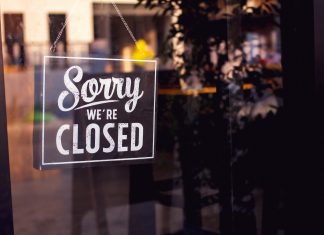 Why Are So Many Restaurants Closing? Vintage "Sorry, we are closed" sign hanging on a glass restaurant door.