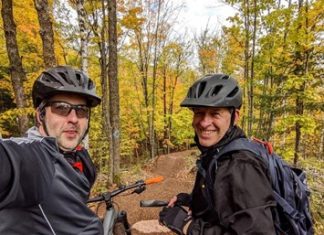 Up North Fall Road Trip Bucket List Two men take selfies as they bike the Tioga Recreation Area in Grand Rapids