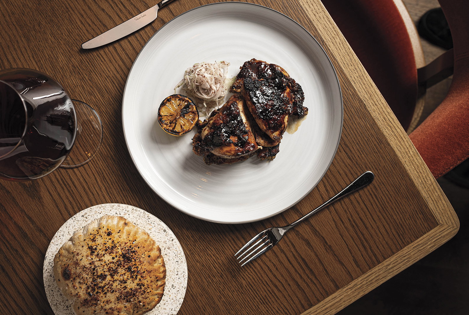 Chermoula-spiced chicken with pita bread and a glass of red wine