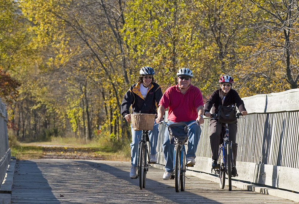 three bikers smiling over a bridge